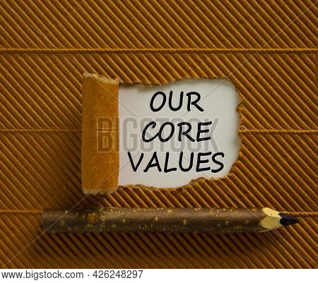 Our Core Values Symbol. Words 'our Core Values' Appearing Behind Torn Brown Paper. Wooden Pencil. Be