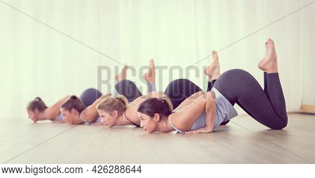 Group Of Young Sporty Sexy Women In Yoga Studio, Practicing Yoga Lesson With Instructor, Forming A L
