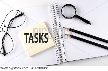 Word Tasks On The Sicker On The Notebook With Pencils,magnifier And Glasses