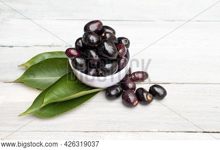 Jamun Or Black Plum In A Bowl With Leaves Isolated On White Wooden  Background With Copy Space, Also