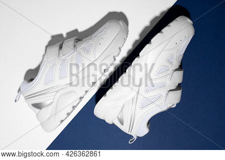 Top View Macro Two White Children Sneakers On The Side With Velcro Fasteners For Comfortable Footwea