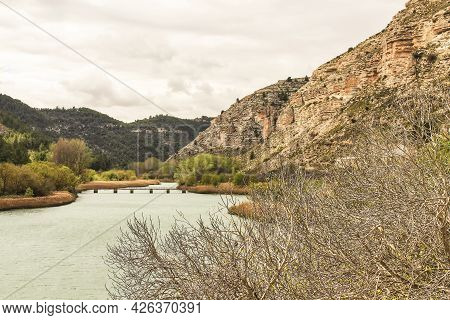 Tolosa Reservoir Surrounded By Vegetation And Mountains In Alcala Del Jucar Village, Albacete, Spain