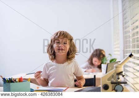 Back To School. Happy Cute Child Is Sitting At A Desk Indoors. Cild Is Learning In Class.