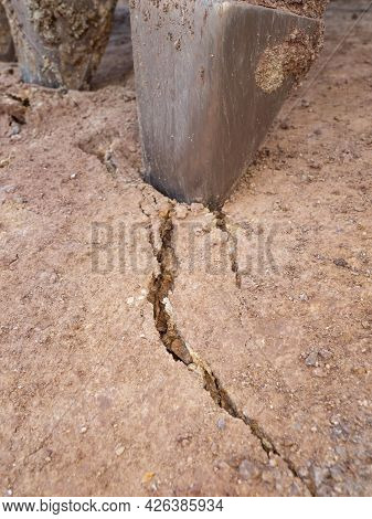 Alloed Steel Teeth Of The Excavator Bucket Bite The Dry Clay. Cracked Ground Under Strong Hydraulic 