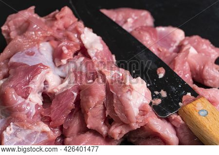 Slice The Pork Or Beef With A Knife On The Table In Close-up. Preparation Of Meat Dishes And Food Pr