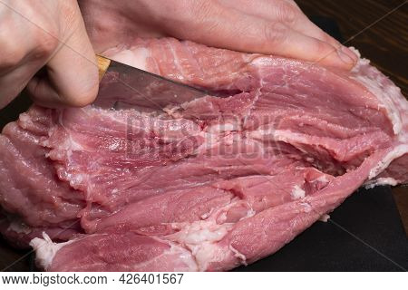 Slice The Pork Or Beef With A Knife On The Table In Close-up.preparation Of Meat Dishes And Food Pro