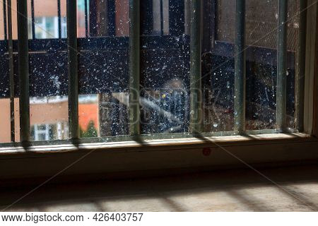 Window With Dirty Glass And Grates . Prison Cell With Security Grates . Low Light In The Window
