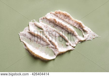 Sample Of Natural Scrub On Green Background. Peeling Cream With Microcapsules. Peach Or Coffee Scrub