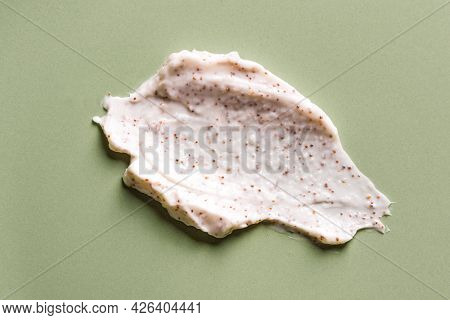 Sample Of Natural Scrub On Green Background. Peeling Cream With Microcapsules. Peach Or Coffee Scrub