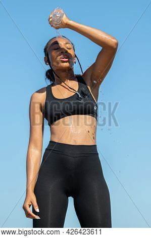 Afro American Refreshing Her Body Pouring Water On Herself: Exercise And Healthy Lifestyle Concept.