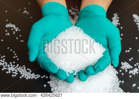 Plastic Beads On Green Gloved Hand. Polymer Beads. The World's Plastic Reduction Policy. Plastic On