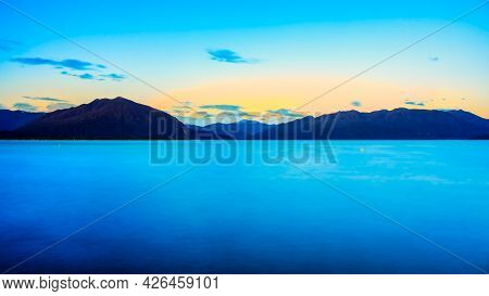 Long Exposure At Lake Brunner Very Early Morning As The Sun Rises Above The Southern Alps Mountain R