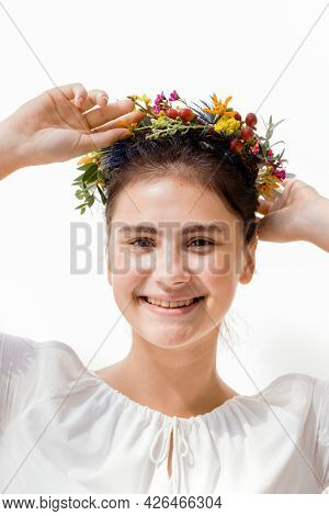 Beautiful young woman with a midsummer floral wreath
