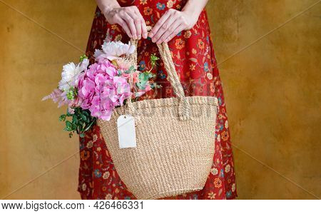 Woman carrying flowers in a wicker bag