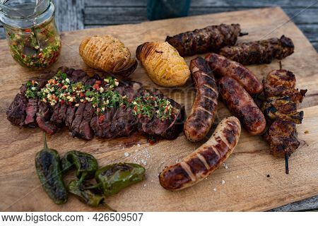 Spicy Grilled Meat On A Rustic Wooden Cutting Board. Close Up With Short Depth Of Field.