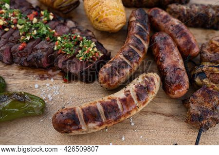 Spicy Grilled Meat On A Rustic Wooden Cutting Board. Close Up With Short Depth Of Field.