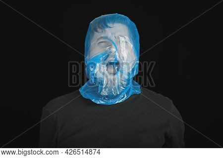 Blue Garbage Bag On Man Head. Exit Bag For Suicide. Self-asphyxiation Concept. Suicide Bag On Man He