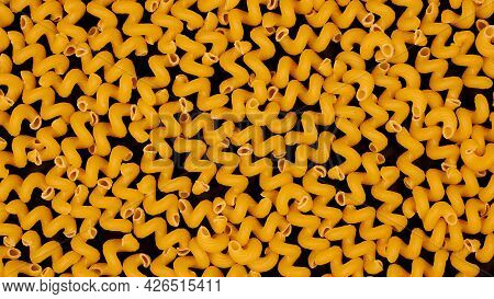 Italian Spiral Pasta On Black Background. Bunch Of Helical Amori Texture For Backdrop. Uncooked Cava