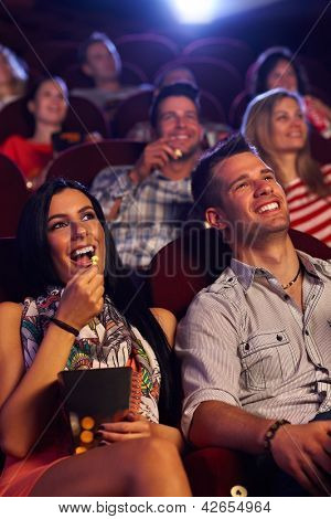 Genç Çift, sinema, Film, patlamış mısır, yemek oturan gülümsüyor.