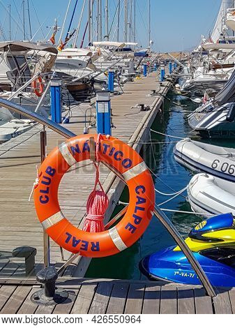 Calpe Spain - August 24 2016; Long Marina Pier With Boats Moored Along Both Sides And Orange Buoy Wi