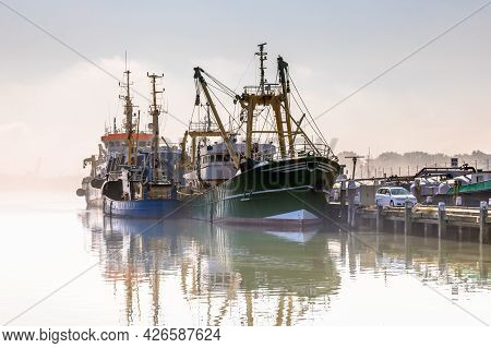 Modern Fishing Ships In Hazy Weather Circumstances In Harbour Of Stellendam, Zeeland Province, The N