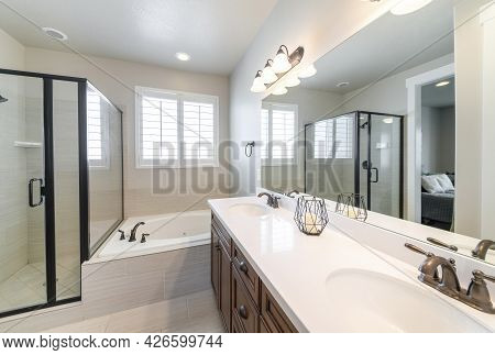 Interior Of A Master Bathroom With Double Vanity Sink And Windows