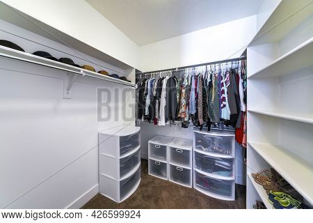 Walk-in Closet With Plastic Wardrobe Storage And Wall Mounted Shelves And Rods