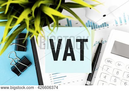 Text Vat - Value-added Tax On Blue Sticker, Calculator, Pen, Piggy, Graphs, Plant. Business Flat Lay