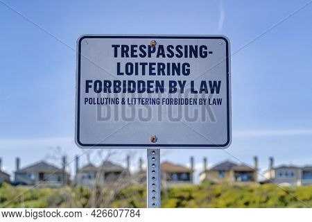 Trespassing Loitering Forbidden By Law Sign Against Blue Sky On A Sunny Day