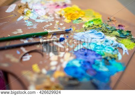 Palette With Multi-colored Paints And Brushes, Woman Painting Picture. High Quality Photo