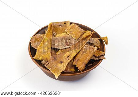 Dried Dog Treats In A Brown Clay Bowl On A White Background. Thin Slices Of Dehydrated Cow Udder. Tr