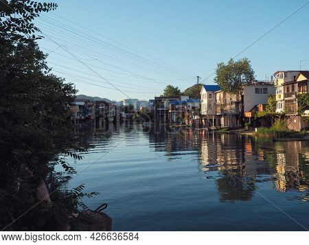 A Calm River Flows Between Private Residential Buildings Located Along It