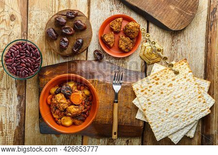Jewish Dish Chelnt With Meat On A Stand Next To Matzo, Fork And Ingredients. Horizontal Photo