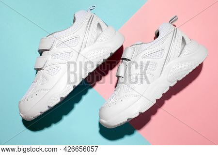 Top View Two White New Sneakers On The Side With Velcro Fasteners On A Soft Pastel Geometric Paper P