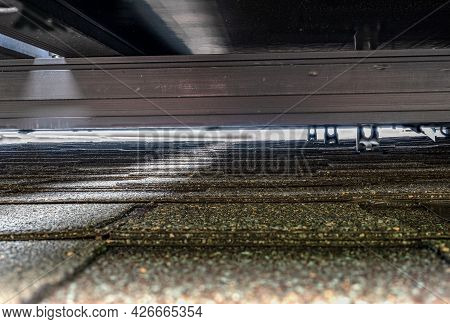 Gap Underneath Solar Panels And Asphalt Shingle Roof With Rails And Anchors Visible.