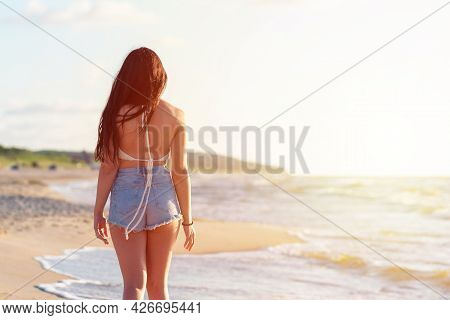 Lonely Young Woman Walking On The Beachsunset Day.beach Woman In Fashion Beachwear Relaxing Walking 