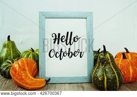 Hello October Typography Text With Pumpkin Decoration On Wooden Table
