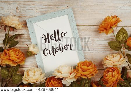 Hello October Typography Text With Flower Decoation On Wooden Background
