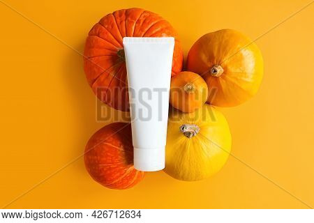 Unbranded White Squeeze Bottle Cosmetic Tube And Different Pumpkins A Lot Yellow Background.  Mockup