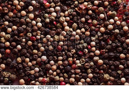 Pepper Background. Black, Red, White Pepper Peas Scattered On The Table