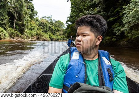 Tourist Enjoying Scenic Nature View Of Tembeling River Cruise With Lush Rainforest Foliage At Taman 
