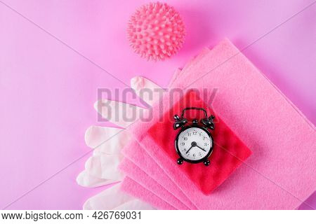 Pink Cleaning Set. Alarm Clock, Rag, Foam Rubber Sponge, Laundry Ball And Latex Gloves On Pink Backg