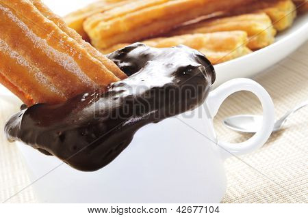 a pile porras, thick churros typical of Spain, dipped in hot chocolate