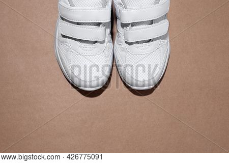 Mock Up Flat Lay Two White Womens Sneakers With Velcro Fasteners With Copy Space Isolated On A Brown