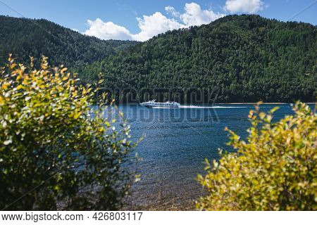 Cruise Ship Is Sailing On Blue Clear Water On Green Wooded Hills Background. Organization Of Recreat