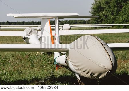 Glider Fixed-wing Motorless Aircraft Covered Standing On Airdrome Parking Lot, Soaring Club Airfield