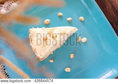 Coconut Cream Pie In The Turquoise Dish On The Wood Table That Topping With Macademia. Shooting In T