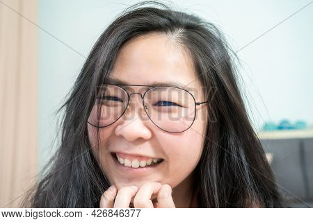 Close Up To Confident Young Asian Small Eye Woman Is Smiling In Her Bedroom.