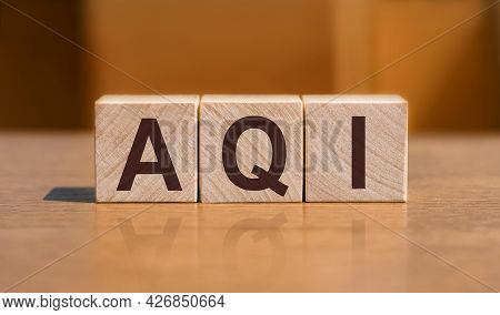 Aqi Abbreviation Of Air Quality Index Text On Wooden Cubes On Orange Wall Background.