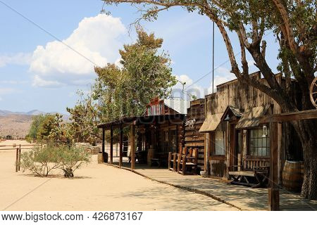 July 14, 2021 In Pioneertown, Ca:  Wooden Boardwalk Besides Historical Wooden Buildings And Cottonwo